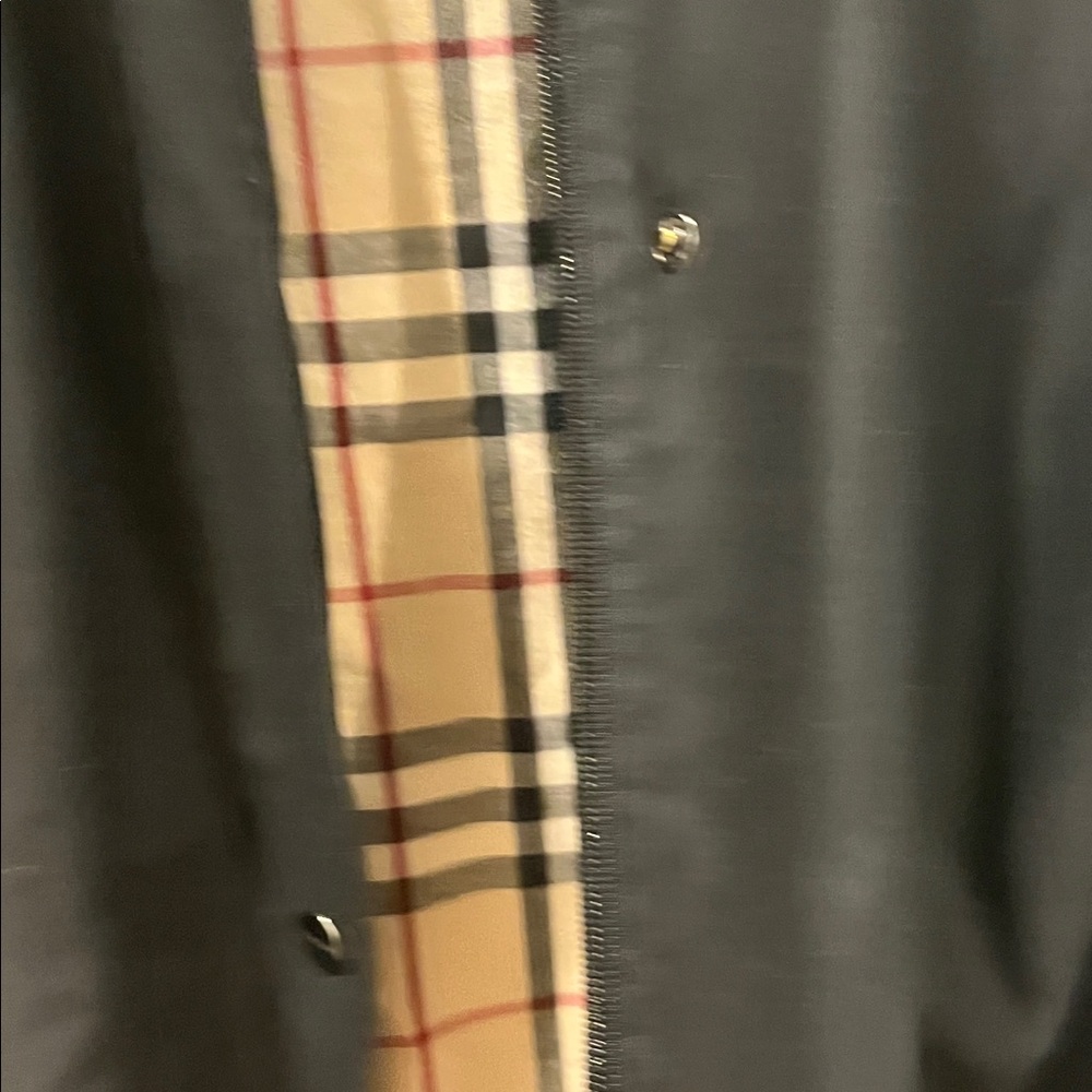 Woman’s Burberry Black Trench Coat with plaid accents and hood.